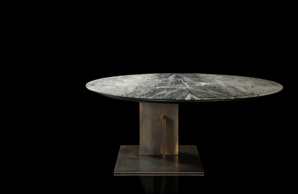 Round Shift Table Lounge. Central leg burnished black steel, top in gray and black marble on a black background.