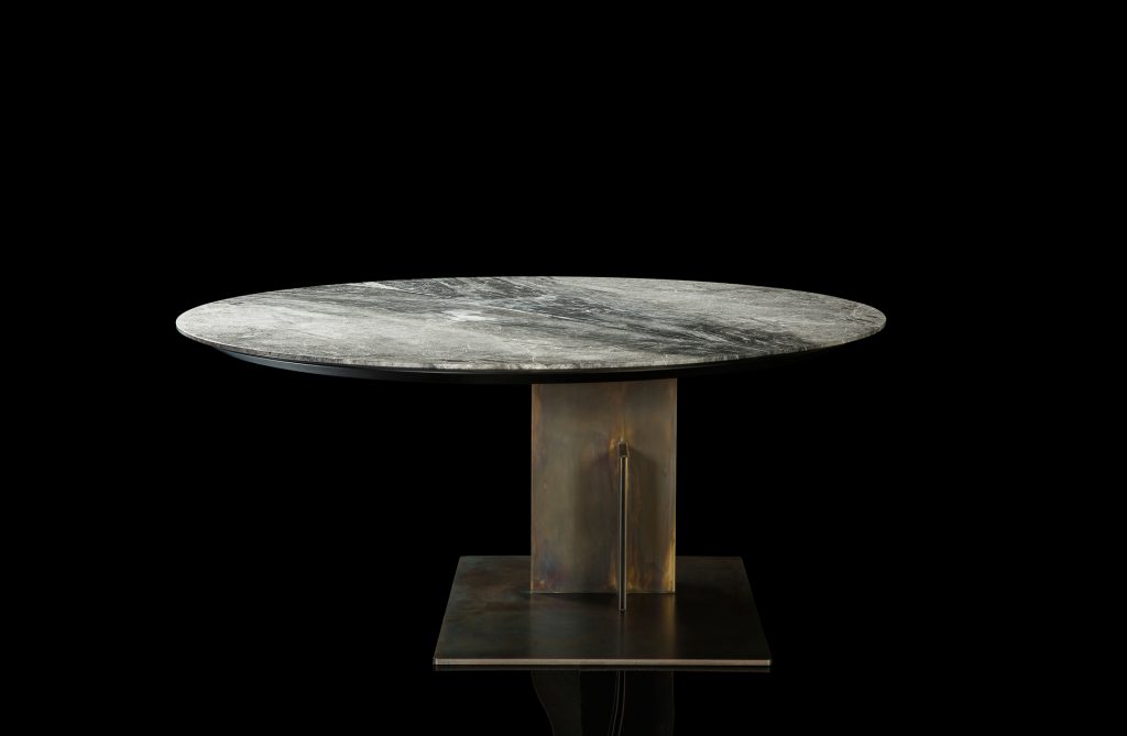 Round Shift Table Lounge. Central leg burnished black steel, top in gray and black marble on a black background.