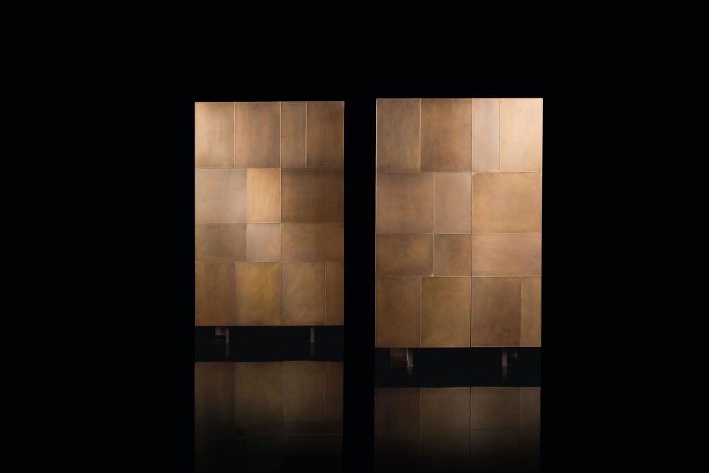 Two Slim Sides Vertical, finish and two legs in brass with a pattern of squares and rectangles on a black background.