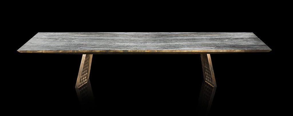 Stealth Table, legs in brass finish with rhombus pattern, top in gray grained wood stone on a black background.