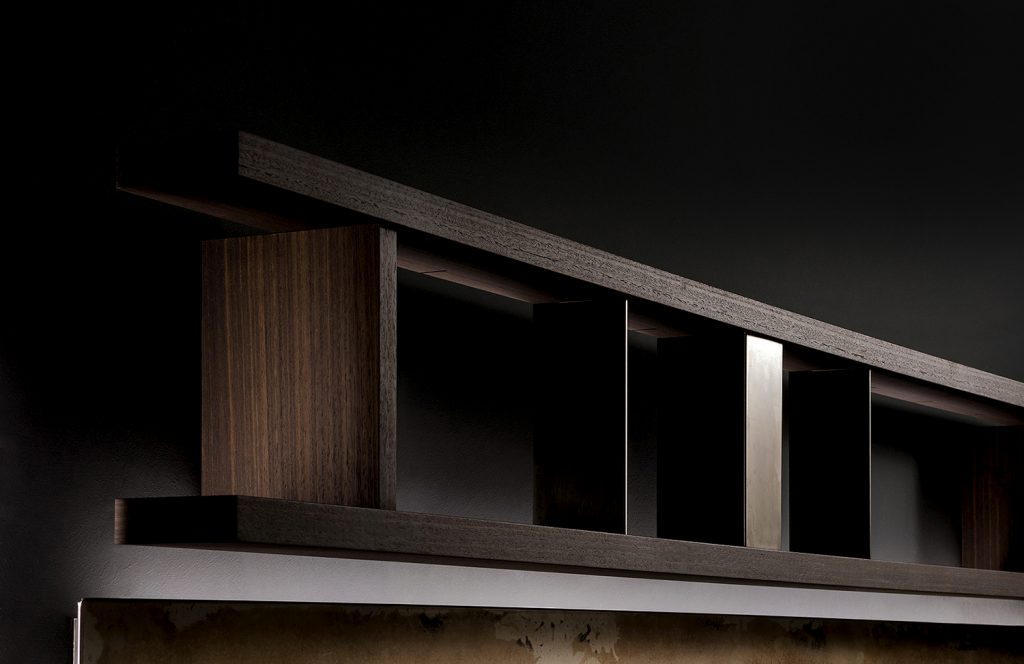Closeup of Style Set bookcase, structure in natural wood color. Storage units, internal partitions and tv panel in burnished platino on a black background.