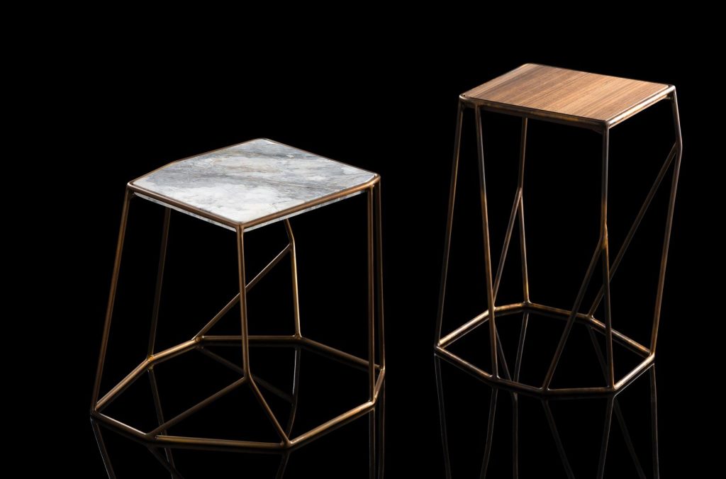 Two W Tables, structure in rod metal color bronze, diamond like shape. Top one in natural wood and one in white and gray marble on a black background.
