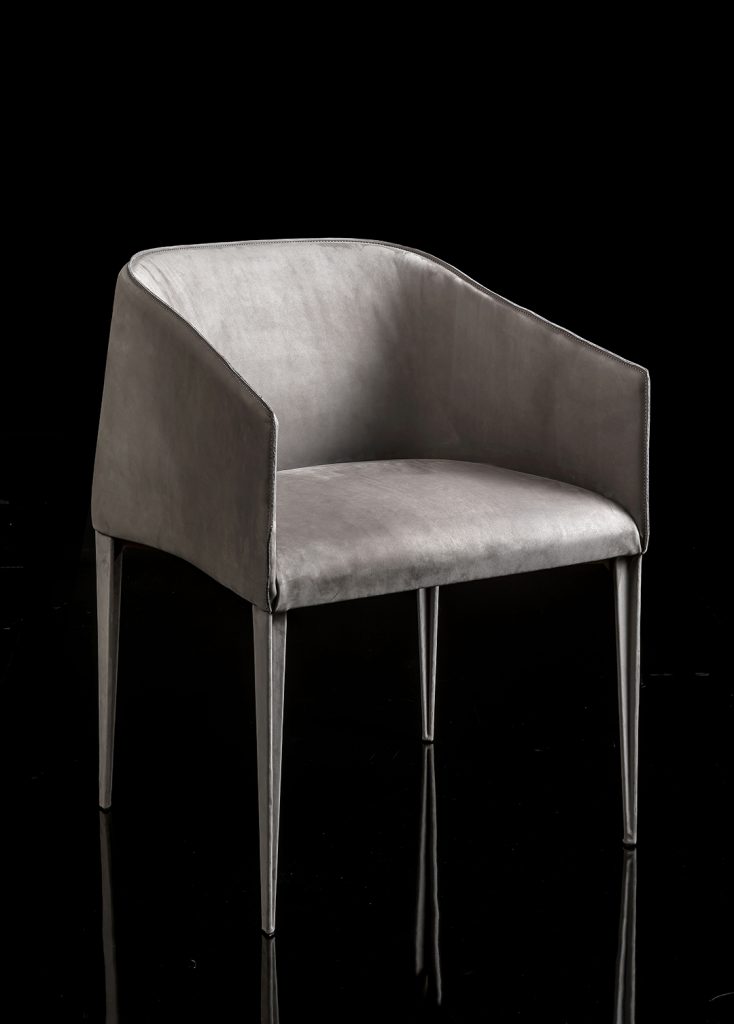 Zagg Chair, upholstered in gray fabric and four legs in silver steel on a black background.