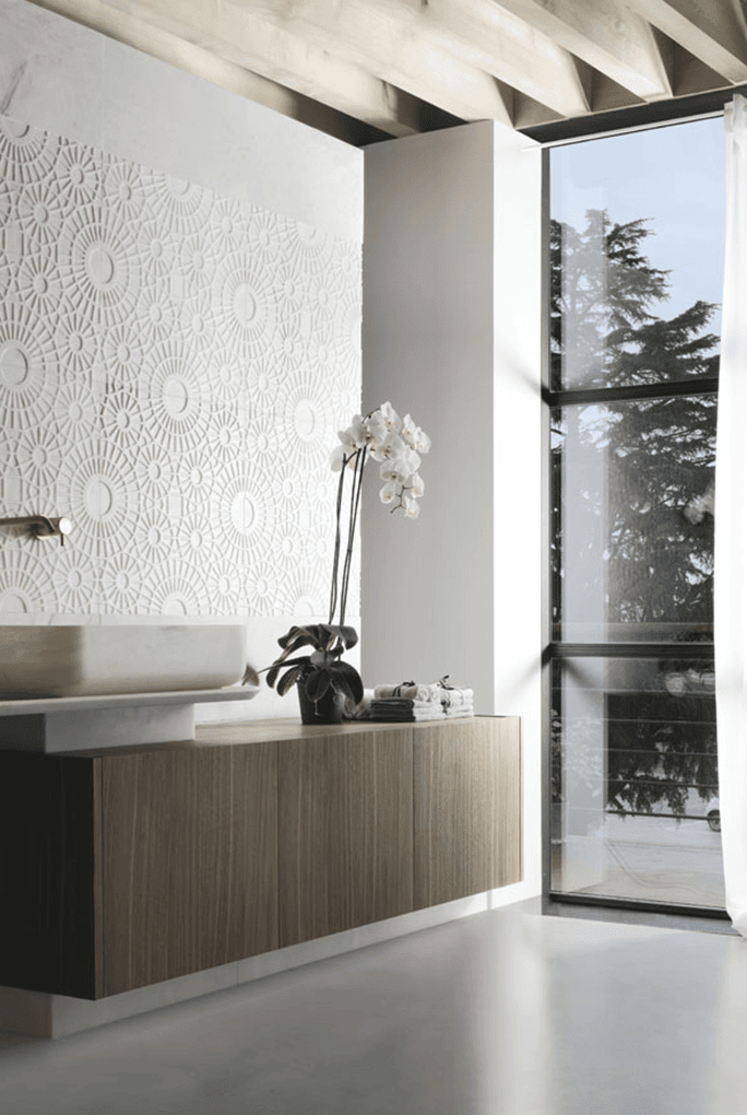 Merletto finish mosaic in white with lace-like patterns on a wall in a living room.