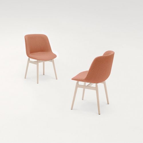 Two Adele Chairs with four natural wood legs, upholstered in pink fabric on a white background.