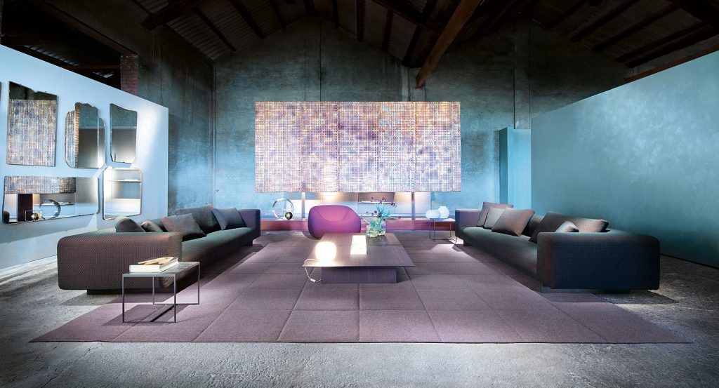 Two Atollo Next modular sofas, upholstery in grey fabric, legs in steel in a living room.