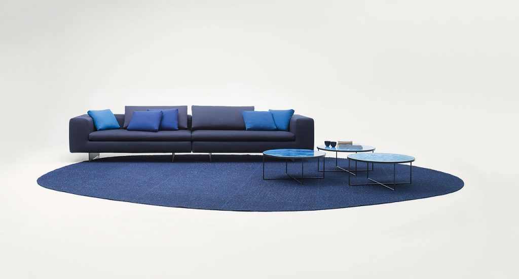 Atollo Next modular sofa, upholstery in grey fabric, six legs in steel on a white background.