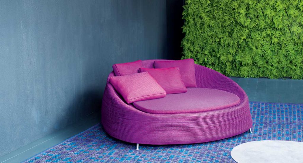 Pink Afra Large seat, upholstery structure of rope cord sewn with a spiral-like pattern, seat cushion in fabric on a terrace.