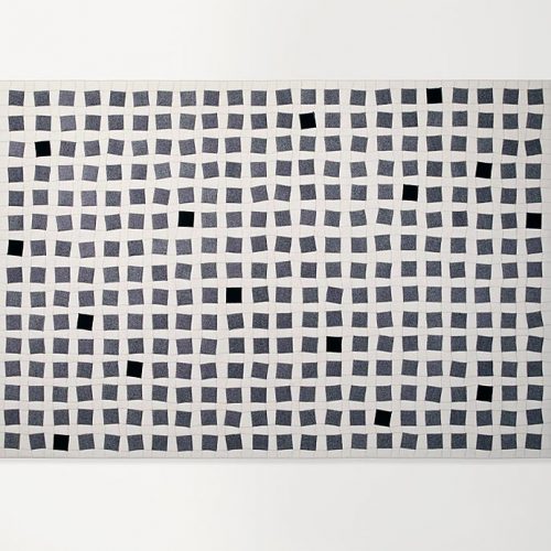 White Continuo rug with grey and black squares like pattern on a white background.