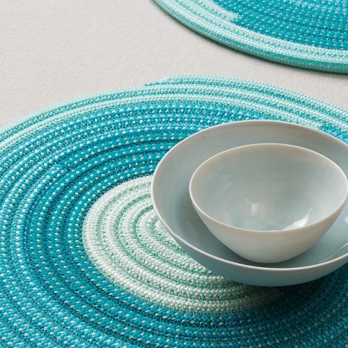 Two blue round Dining Mats on a white background.