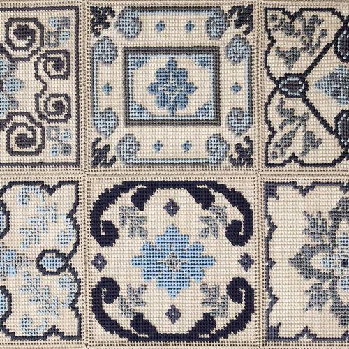 Donna Costanza rug embroidered with gray, blue, black and beige flat braids of abstract pattern.