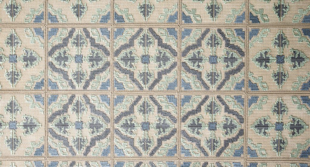 Donna Florio rug, embroidered with gray, blue, green and beige flat braids with a diamond like pattern.