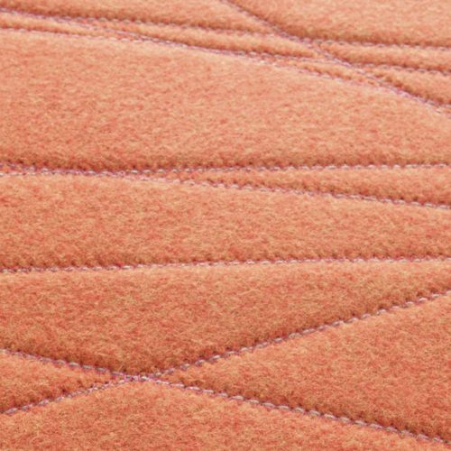 Flussi rug made of orange felt and embriodered in a rectangle.