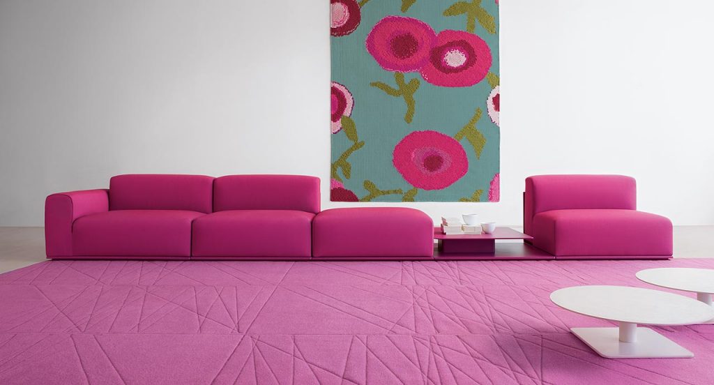 Pink Flussi rug made of felt and embriodered in a rectangle in a living room.