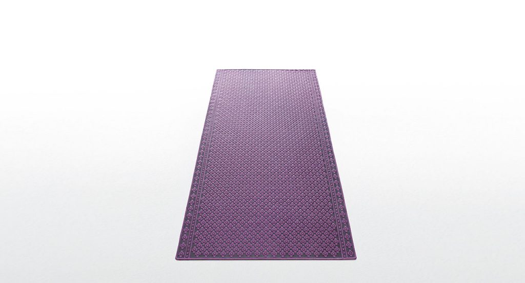 Giardino rug. The embroidery is made of grey and purple flat braid on a white background.