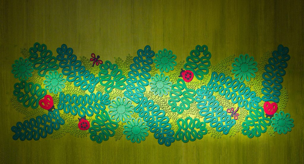 Ladybird rug, plants and animals like pattern in color green, black, and red on a green background.