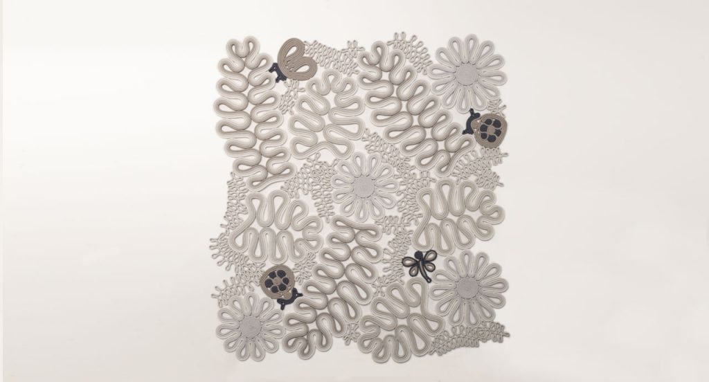 Ladybird rug, plants and animals like pattern in white, brown and grey on a white background.