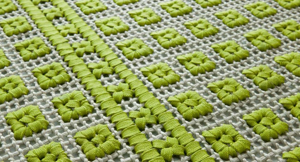 Orto rug, embriodery made of white and green flat braids.