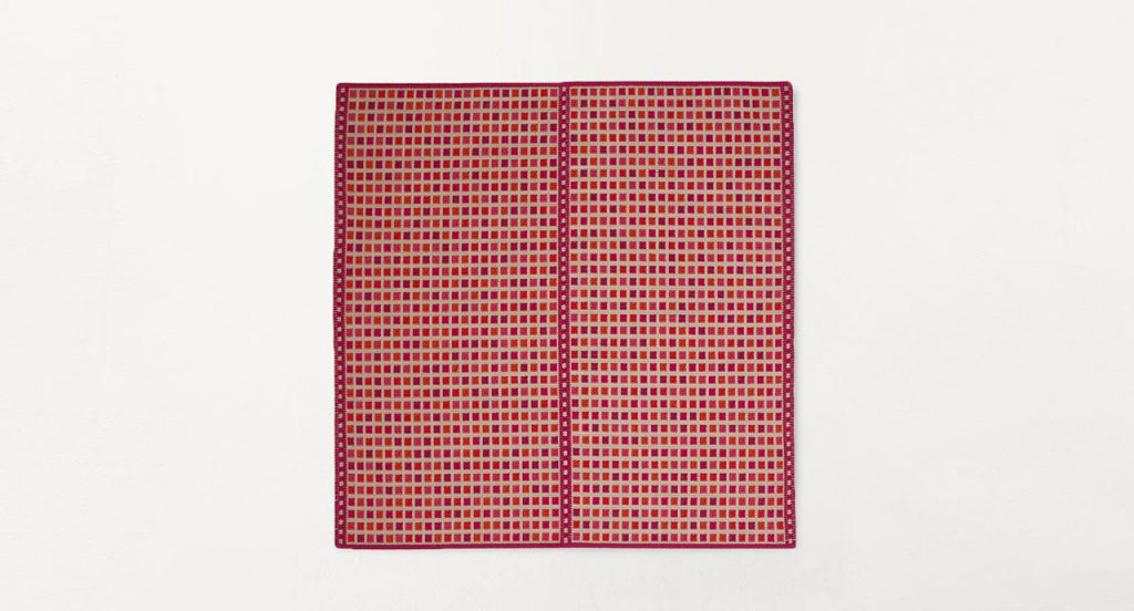 Orto rug, embriodery made of white and red flat braids on a white background.