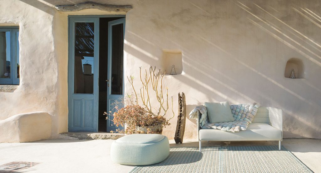Orto rug, embriodery made of white and blue flat braids in a living room.