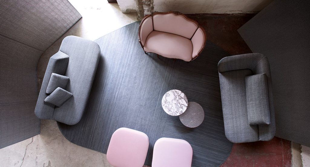 Parallelo rug, irregular shape made of grey wool cords in a living room.