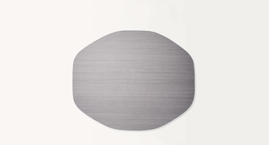 Parallelo rug, irregular shape made of grey wool cords on a white background.