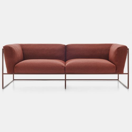 A corten match Arpa sofa for three seats. Backrest and seat brown loadbearing structure in stainless steel, epoxy powder coated.The backrest frame is woven using high tensile polyester cord. The back and seat cushions are made of Dryfeel on a white background.