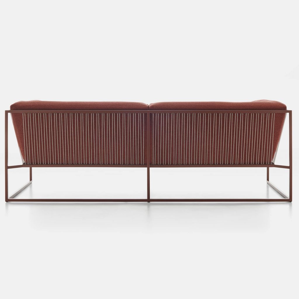 A corten match Arpa sofa for three seats. Backrest and seat brown loadbearing structure in stainless steel, epoxy powder coated.The backrest frame is woven using white high tensile polyester cord. The back and seat cushions are made of Dryfeel on a white background.