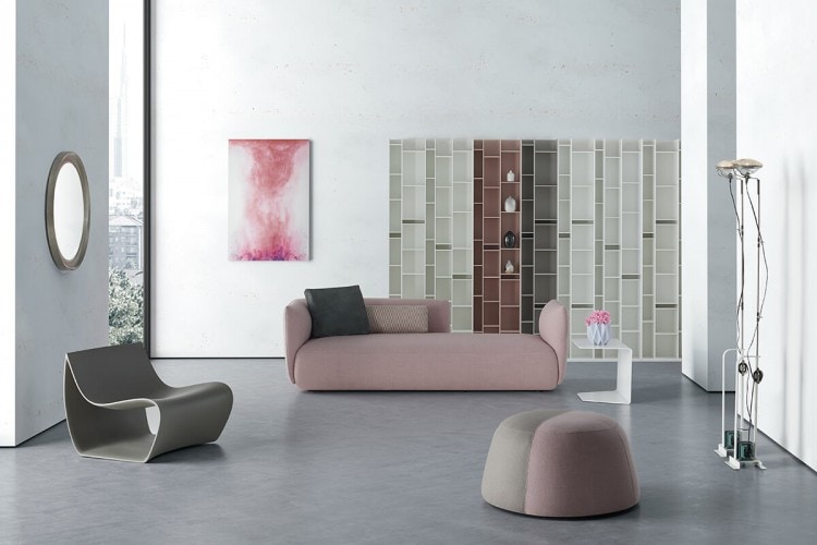 A powder pink Cosy sofa with high backrest on the left in the background of a living room.