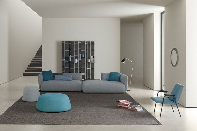 A grey Cosy sofa made of two padded modular elements, one with the high back on de right and one on the left on a living room background.