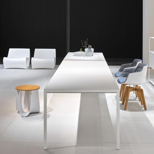 A Extension table, the laminate tabletops and extension tops in Fenix are built-in and are reinforced internally by thick aluminium sheets with four legs in aluminium on a dining room background.