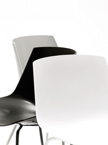 Three flow Chairs Padded, two color white with a white bottom and one color black with a white bottom on a office background.