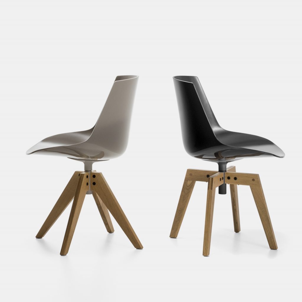 Two Flow Chairs Padded, one color white with natural wooden bottom and one color black with a coffee bottom on a office background.