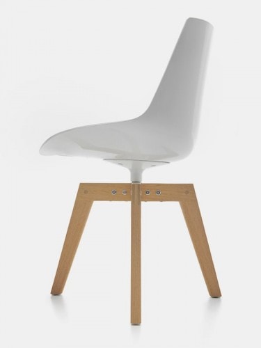 A white Flow Chair Iroko with four-legged in natural oak on a white room background.