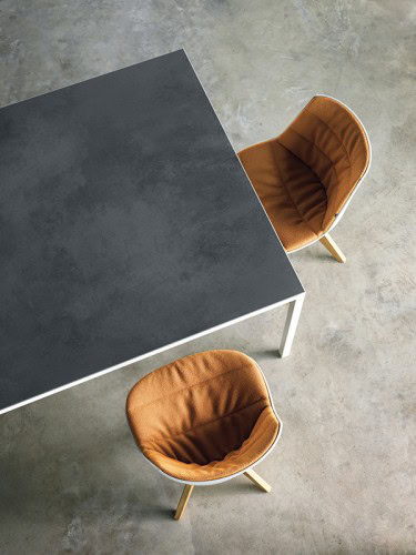 Two orange Flow Chairs Padded with natural wooden bottom on a office background.