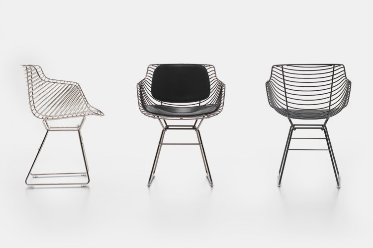 Three Flow Milo chairs made of steel core in nickel chrome finish, one with a black leather padding covering and backrest on a white background room.