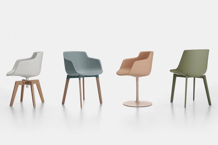 Four Flow Leather chairs, one in white with four legged natural oak colour, one in rugiada with four legs cross oak base in natural oak colour, one in pesca colour with a central leg in power pink colour, one in salvia colour with a legged cross base in green colour on a white background