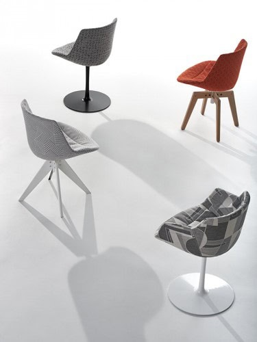 Four Flow Textile chairs, one in orange pattern with four-legged in natual oak, one in grey pattern with a white central leg, one in gray pattern with four-legged steel in white and one in grey pattern with a white central leg on a white background