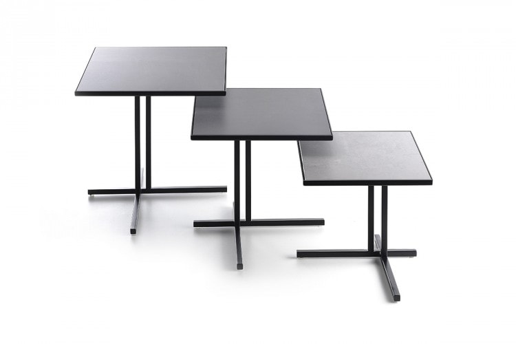 Three dark grey K Tables, tabletops in ceramic and separate frames in steel on a white background.