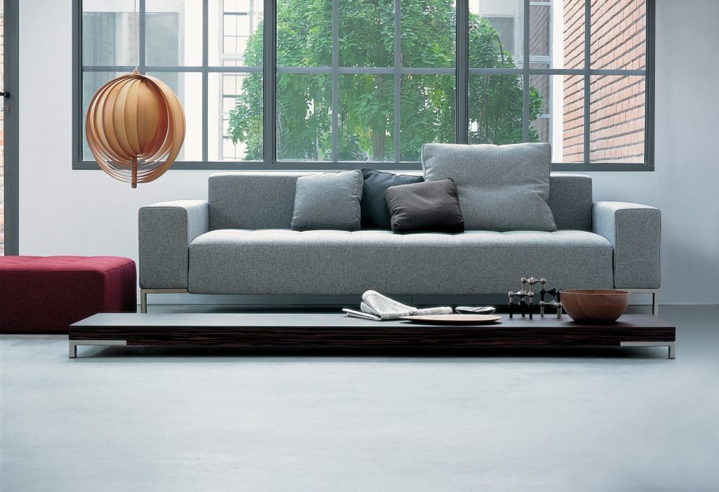 Alfa sofa with a rectangular grey seat and backrest, featuring silver legs in a living room.