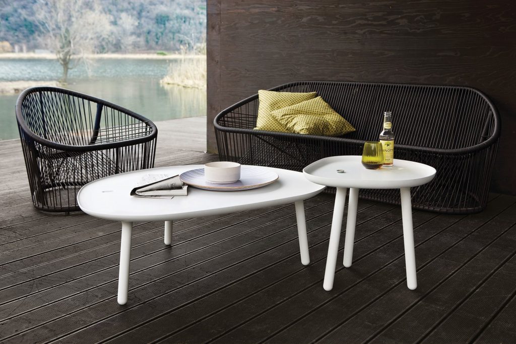 Two Club armchairs, seat, backrest and frame in brown metal in a garden.