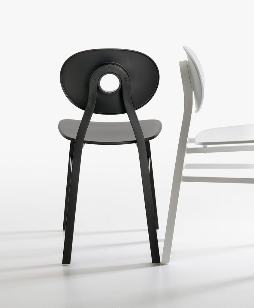 Two Elipse chairs, one in black and one in white with round back with four legs on a white background.