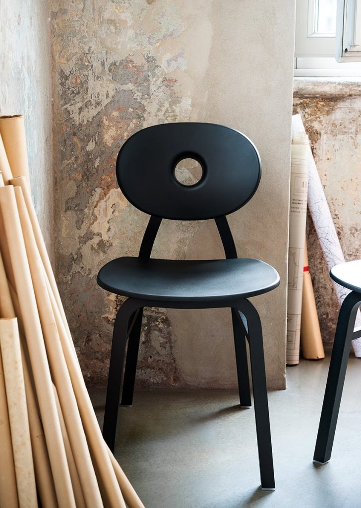 Two Elipse chairs in black with round back with four legs in a dining room.