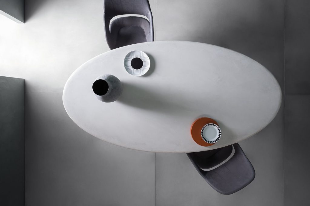 Fenice table with an oval top and oval central leg in white in a dining room.