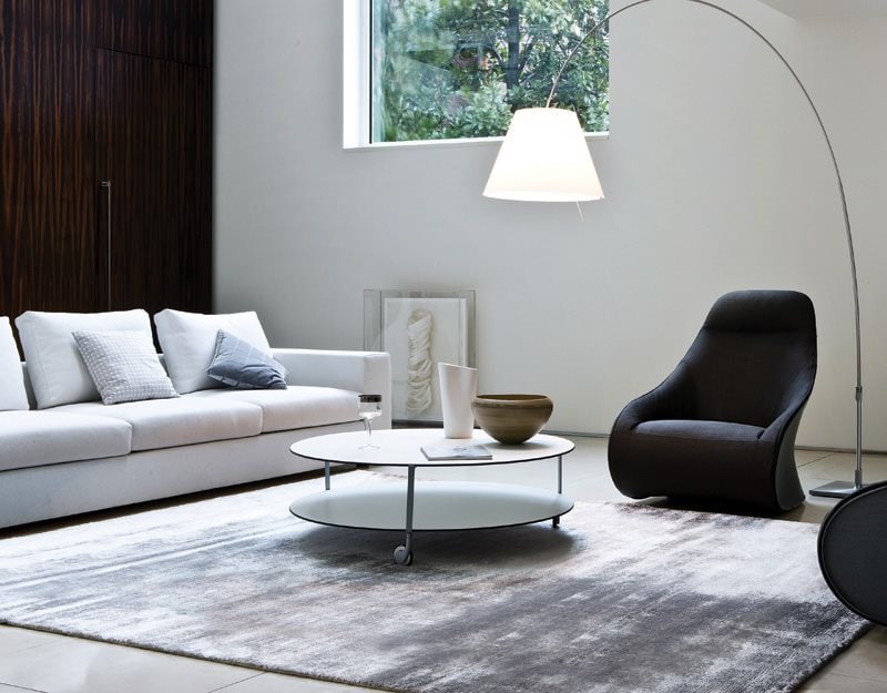 Giro table with white round top and base and three metal structure legs in a living room.