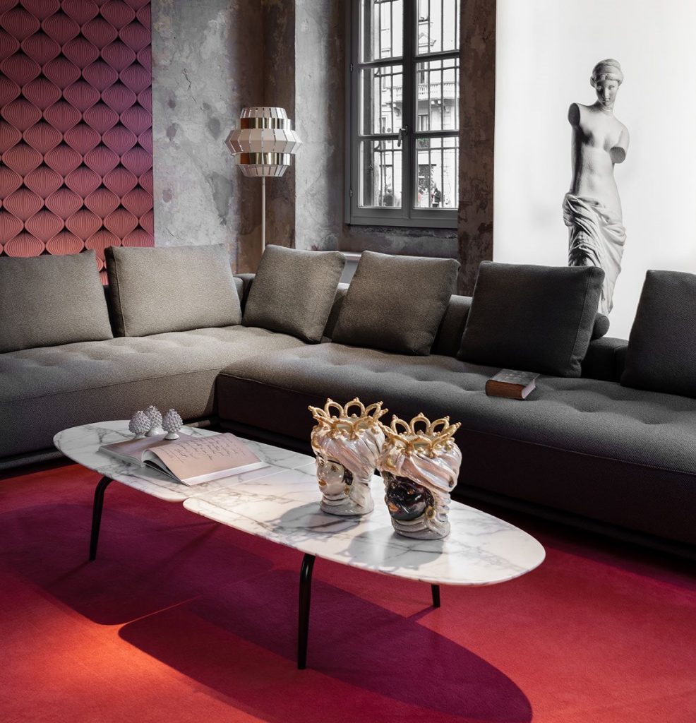 Graphium coffee table. Oval white and gray marble top and four black legs in a living room.