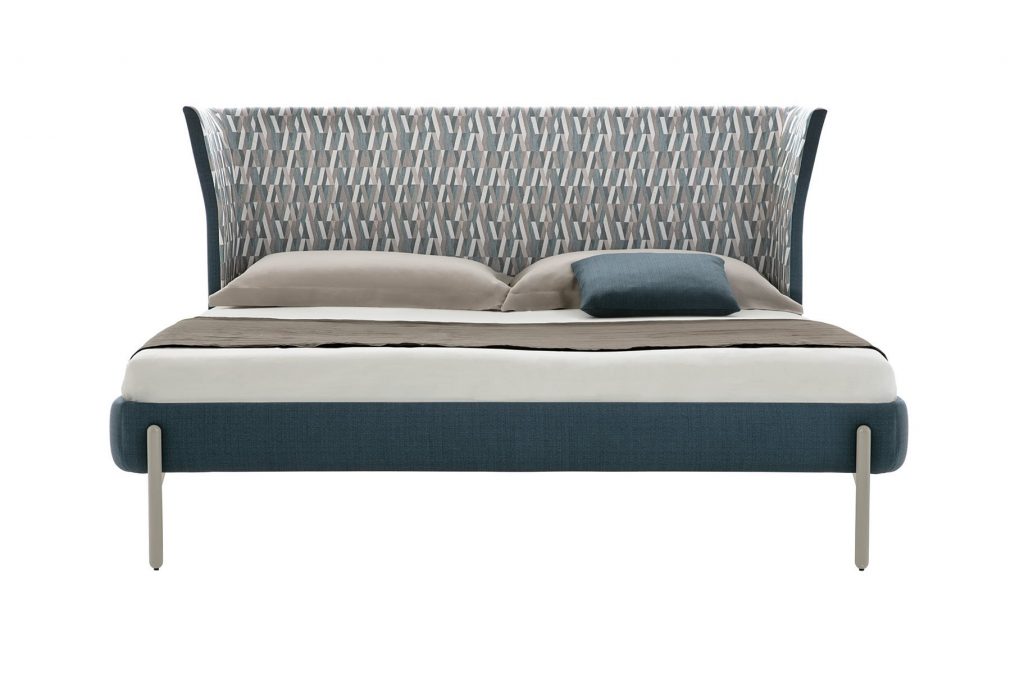 Greta bed with headboard upholstered in blue fabric flower pattern with four silver steel legs on a white background.