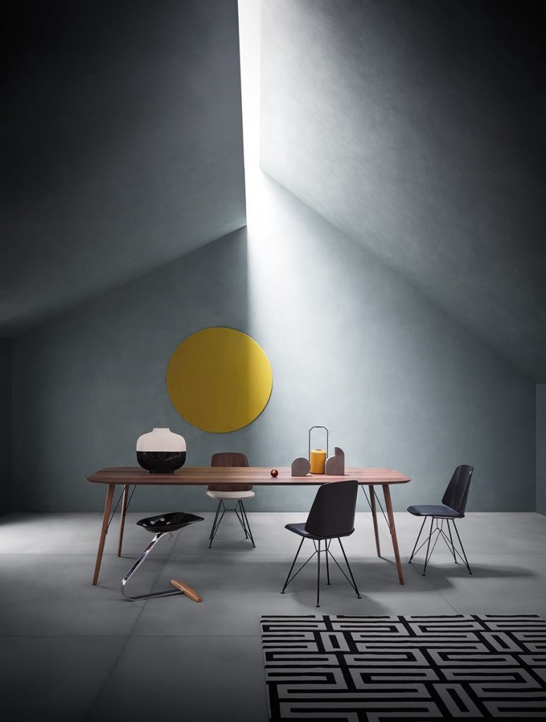 Three June chairs with a black cushioned seat and backrest in a dining room.