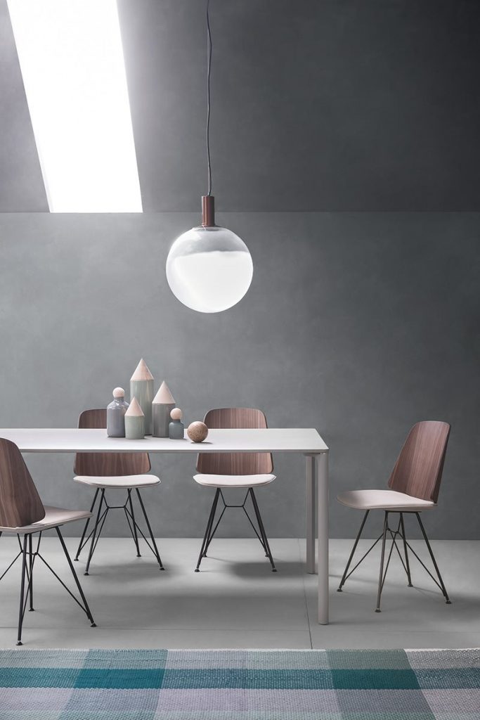 Four June chair with a white cushioned seat and natural wood backrest on a gray background.