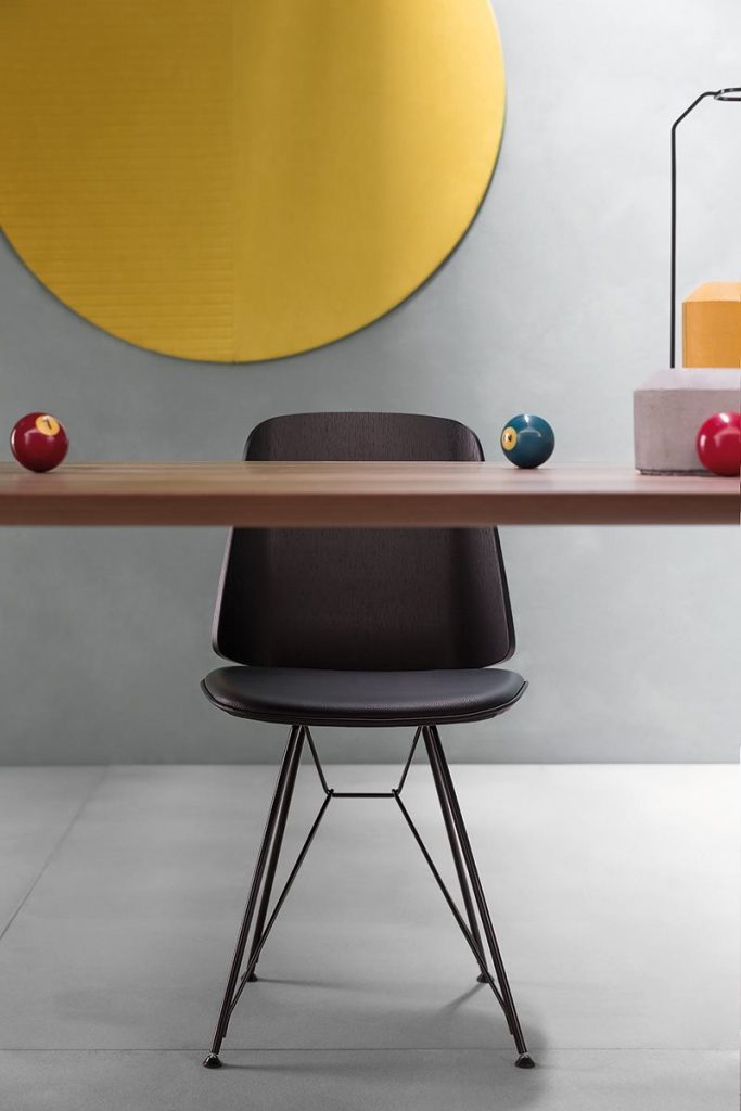 June chair with a black cushioned seat and backrest in a dining room.